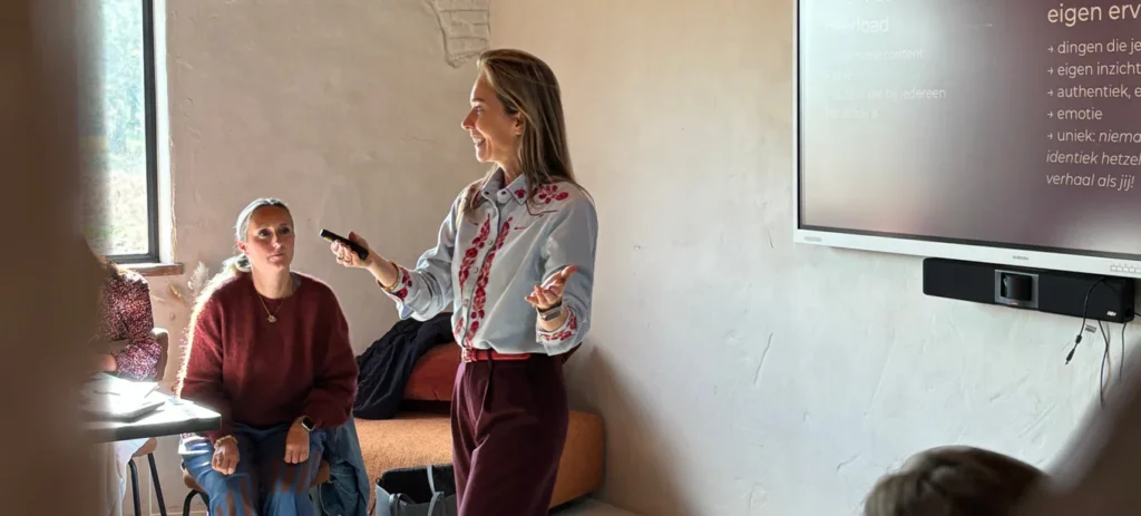Vrouw geeft presentatie voor een scherm in een klaslokaal.